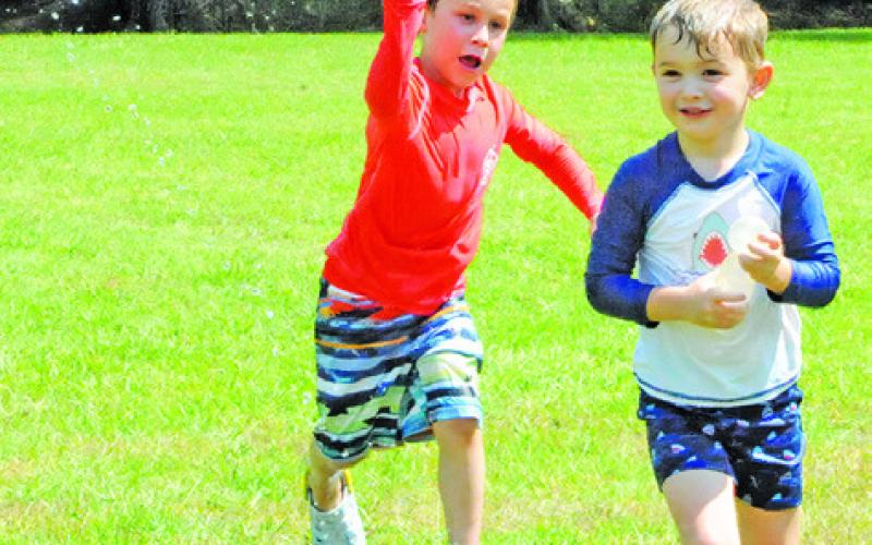 AREA CHILDREN WERE TREATED to a water balloon free-for-all during the Harrie P. Woodson Memorial Library’s special event last Thursday at Davidson Creek Park. -- Tribune photo by Denise Squier