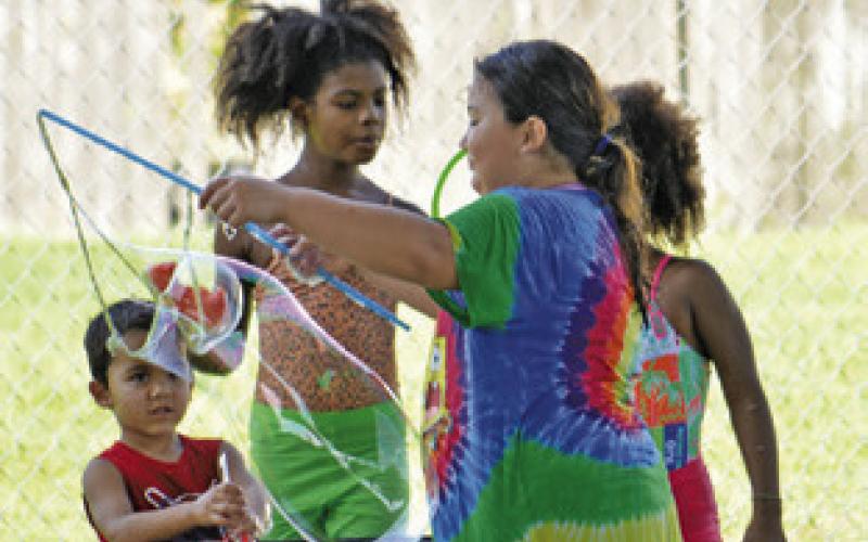 “BUBBLE, BUBBLE, I’M NOT IN TROUBLE...” Children enjoyed making bubbles during the Harrie P. Woodson Memorial Library’s end of summer water party last week. Tribune photo by Kimberly Hutcheson