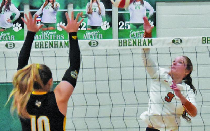 CALDWELL’S MOLLY MEADOWS hits the ball at the net while Sealy’s Jade Barton attempts to block during their bi-district match at Brenham High School. Tribune photo by Roy Sanders