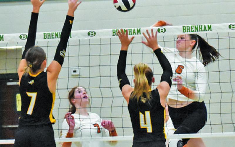 CALDWELL’S KAELY BROWN prepares to hit the ball as Lydia Giese looks on. Also pictured are Sealy’s Lauren Luther and Avery Grigar. Tribune photo by Roy Sanders