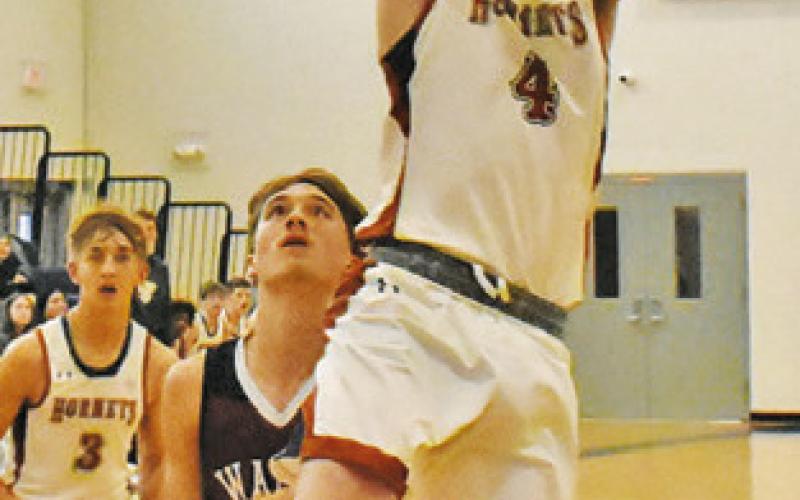 NATHAN SCOTT OF Caldwell leaps high for this shot against Waller JV.