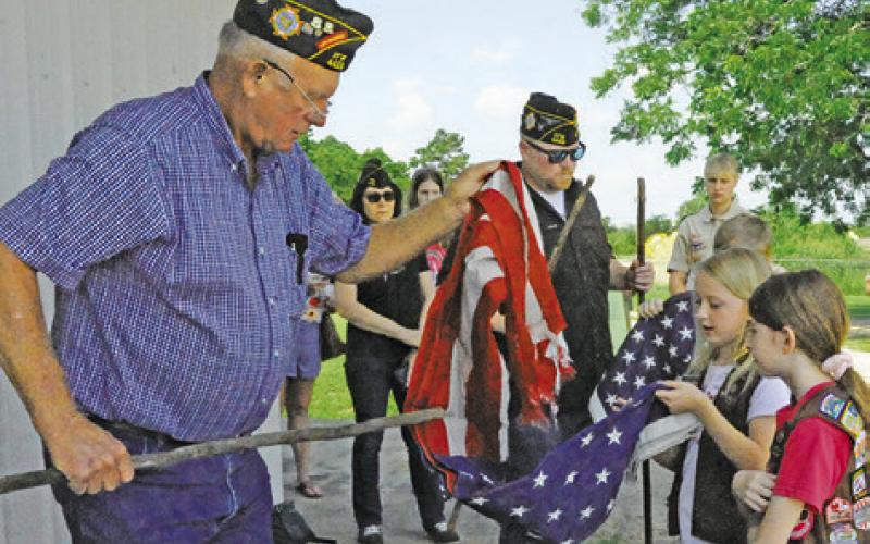 POST SERVICE OFFICER for VFW Post 4458 help children prepare old tattered U.S. Flags for burning during Friday’s flag retirement ceremony. -- Tribune photo by Denise Squier
