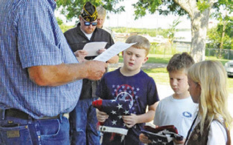 FRANKLIN KARASEK, VFW Post 4458 Post Service Officer, leads last Friday’s flag retirement service at the post. Area children presented three flags to retire by burning during the Friday morning ceremony.