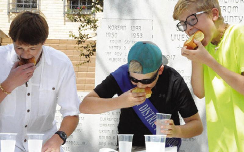 THE GUYS EAT kolaches as fast as they can during the eating contest to be named the winner. Tribune photo by Denise Squier