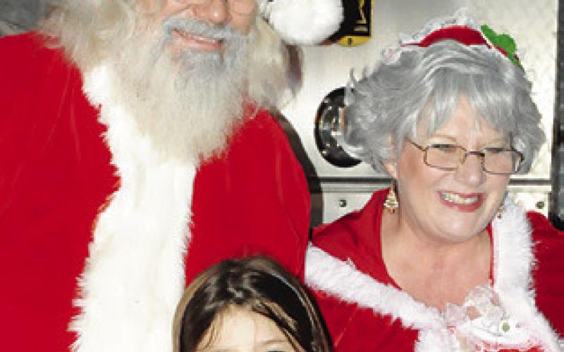 SANTA AND MRS. Claus took time out to pose with area children for photos during last year’s Christmas on the Square.