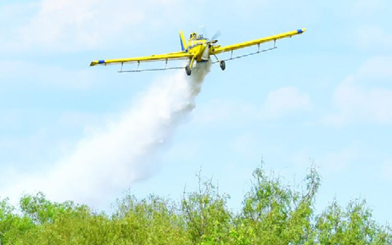 KEN LAUDERDALE DROPS water on the blaze along CR 116.