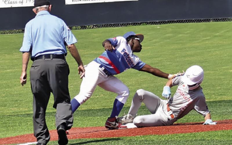 CHASE FAUST IS tagged at third base in the Brookshire Royal game.