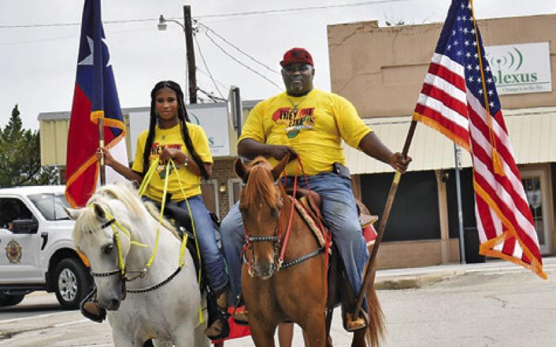 ROGER AND RACHEL Richmond display the American and Texas flags at the Juneteenth Parade on Saturday in downtown Caldwell.