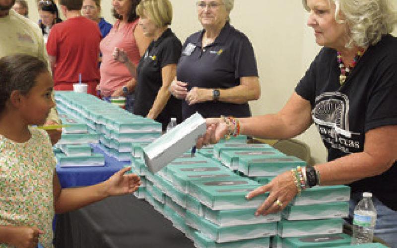 JANICE EASTER GIVES out boxes of tissue, representing Caldwell Main Street, at the Back to School Blast last week. Tribune photo by Denise Squier