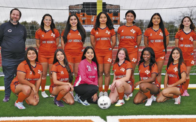 THE 2025-2026 LADY HORNET SOCCER team is, from left, front, Bianca Contreras, Jasmine Rodriguez, Guadalupe Rendon, Adeline Hicks, Amoree Denson, Ashley Yanez, back, Coach Stephen Wehring, Lilly Ayers, Sophia Burguette, Angie Lobo, Isabella Hernandez, Itzel Barrera and Tarah Hott.