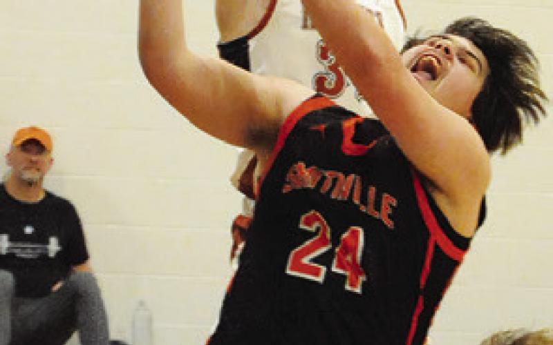 TRAVIS CUNNINGHAM of Caldwell reaches high to block this Smithville shot. -- Tribune photo by Denise Squier