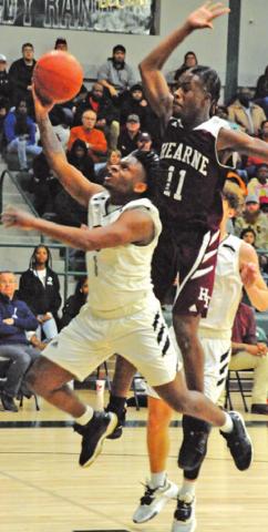 ARVIS BURNS ATTEMPTS to get a shot off while Hearne’s Jabari Dunn defends during last Friday’s area playoff game at Rudder High School. -- Tribune photo by Denise Squier