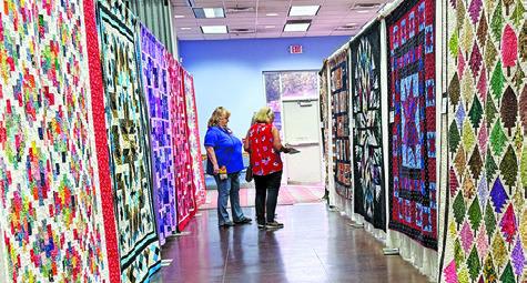 MANY VISITORS TO THE CREATIVE Memories Quilt Guild Quilt Show took time to vote for their favorite creations. Tribune photo by Denise Squier