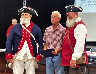 REPRESENTATIVES OF THE SONS of the American Revolution present Ben Ragnes with an award in recognition of his flag maintenance. Tribune photo by Sabine Lazo