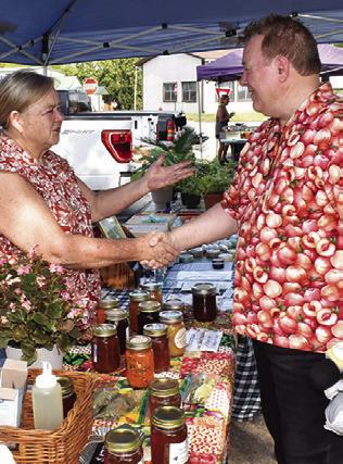 BETH MORRIS of Plethora Farms greets TV star Michael Marks, Your Produce Man, on Saturday at the Farmers Market in downtown Caldwell.
