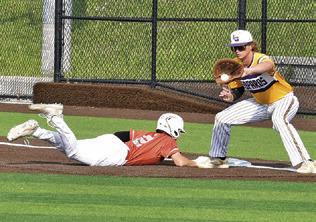 CADEN SCHLUENS SLIDES back into first base last Friday against La Grange. The Hornets won 8-3 and are headed to the playoffs. Tribune photo by Roy Sanders
