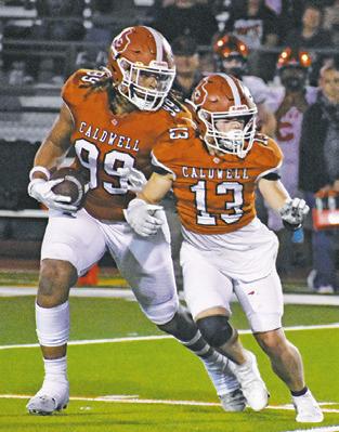 DELVIN MORRIS of Caldwell carries the ball as Thomas Willard prepares to block.