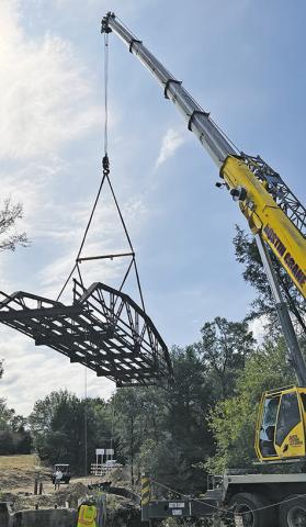 THIS OLD, historic iron bridge off County Road 146 is removed last week for a new bridge replacement. See story inside.