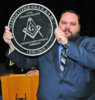 MICHAEL BENNETT displays this medallion presented to the Warren Masonic Lodge by the Burleson County Historical Commission.