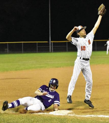 SOMERVILLE’S JAYDEN YOUNG reaches high for this catch as a St. Joseph base runner slides into third base. Tribune photo by Roy Sanders