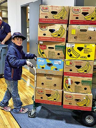A YOUNG VOLUNTEER at last year’s Food for Families Food Drive, which collected over 12,000 pounds of food and over $64,000. Photo courtesy of Janice Easter
