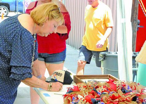 MANY PEOPLE BID ON ITEMS during the silent auction at Saturday’s fundraiser for the Birch Creek Volunteer Fire Department. Tribune photo courtesy of Denise Squier