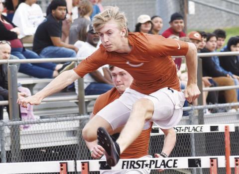 CALDWELL ATHLETE Daniel Cowan clears a hurdle during last week’s Skrabanek Relays in Caldwell. Also pictured is Corbin Stewart.