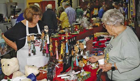 Shoppers examine the festive wares at this year’s Lyons Christmas Cottage arts, crafts, and bake sale. Tribune photo by Roy Sanders