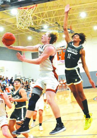 HARRISON NOVAK LEAPS high for this shot against Taylor. The Hornets fell 55-46. -- Tribune photo by Roy Sanders