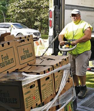 DAVID PALICKA OF In God’s Hands Ministry helps unload this food on Saturday morning at the food pantry in Cade Lake.