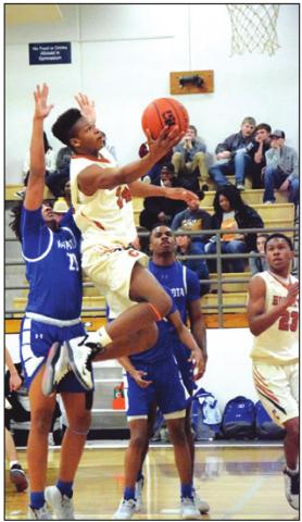 CALDWELL’S JUNIOR Mathis goes airborne to score a basket during the Caldwell-Navasota game. -- Tribune photo by Denise Hornaday