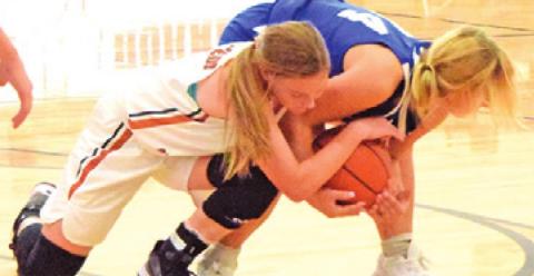 CADIE COSTON BATTLES for possession of the ball during the Caldwell-Victoria St. Joseph basketball game last week.