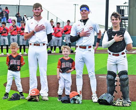 CALDWELL’S CORT HILDEBRAND, Shane Clements and Jake Hibbeler are joined by these Little League players, and future Hornets, for the National Anthem at the Caldwell-Smithville game on Saturday. Tribune photo by Roy Sanders