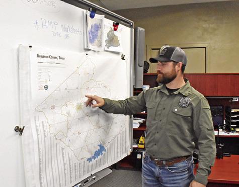 TY ELLER LOOKS at this map in the emergency management office at the Burleson County Courthouse in Caldwell. Tribune photo by Roy Sanders