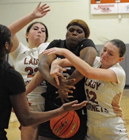 CALDWELL PLAYERS, Kierstyn Macik and Kaely Brown, fight with a Hearne player for possession of the ball during Caldwell’s 44-31 win over Hearne last Tuesday night in Hornet Gym. Tribune photo by Denise Squier