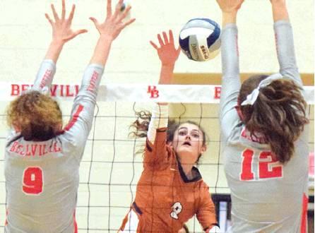CALDWELL’S CORINNE DILLARD hits the ball through the arms of Bellville’s Sadie Mckay and Madison Morgan Friday night during the Lady Hornets four-set win. -- Tribune photo by Denise Hornaday