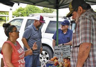 ALISA HAIRSTON, LEFT, talks to customers on Saturday at the Farmers Market in Caldwell.