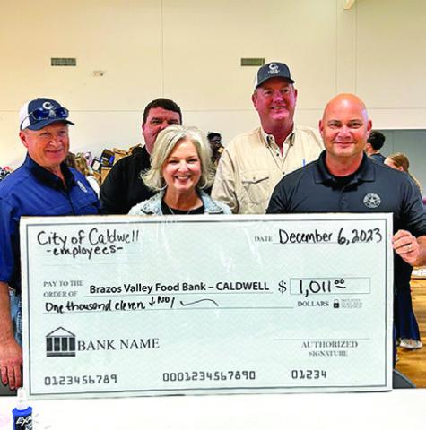 CALDWELL FOOD FOR FAMILIES food drive volunteers with a donation check from the 2023 food drive, which collected over 13,000 pounds of food and $60,000 in monetary donations. Photo courtesy of Janice Easter