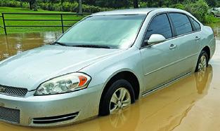 THIS CAR STALLED while crossing flood water near Cade Lakes on Monday.