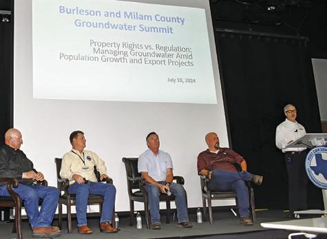 JOHN DUPNIK, AT the podium, moderates a discussion on property rights versus regulation. Also pictured are, from left, Alan Day, Gary Westbrook, Billy Howe and James Totten.