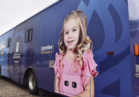 LYNNLEE KOCUREK stands next to this picture