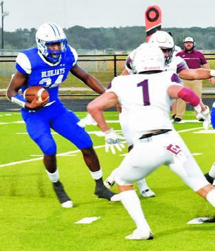 SNOOK’S MARK Moore carries the ball against Iola last Friday in Snook. Snook lost its opener 27-24. -- Tribune photo by Roy Sanders