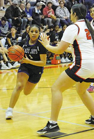 ALANA STRINGFELLOW drives to the basket while Gracee Greiffenstein defends during the Snook-Somerville game last Tuesday. Tribune photo by Denise Squier