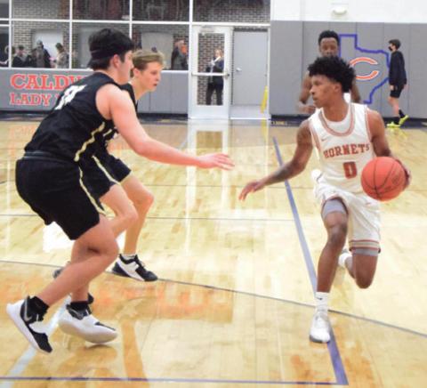CALDWELL’S LARRY DAVIS drives down the court while two Rogers’ players defend during last Tuesday’s home district game.