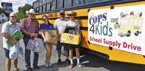 COPS 4 KIDS HOLDS their school supply drive on Monday at the Walmart parking lot. Pictured are Peter Glidewell, Burleson County Sheriff Bill Rios, Alyssa Schenk and Michael and Wyatt Hester.
