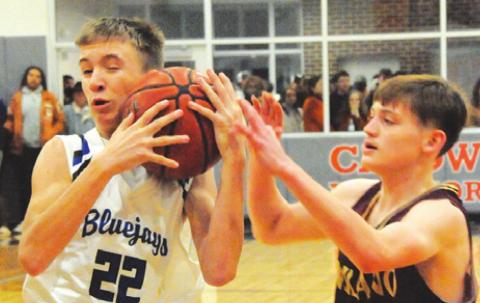 SNOOK’S BRETT WITHEM fights with Milano’s Mykal Hutson for possession of the ball during the Bluejays-Eagles area round battle last Friday night in Caldwell. -- Tribune photo by Denise Squier