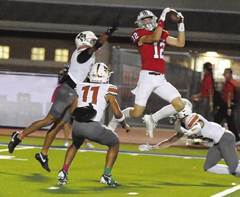 CALDWELL’S DYLAN CARTER, Zane Brown and Krush Strange defend as this Madisonville receiver makes a catch. Tribune photo by Denise Squier