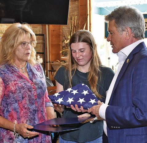 U.S. REP. MICHAEL McCaul presents this U.S. Flag to Sherri Hermes, left, and Caylee Hermes, center, in honor of former Burleson County Sheriff Gene Hermes, who recently died after a long law enforcement career in the county. McCaul presented the flag on Tuesday, June 17, at Lissa’s Sip &amp; Shop in downtown Caldwell.