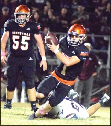 SOMERVILLE QUARTERBACK PHILIP Haba gets away from Flatonia’s Jovanni Venegas during Friday’s district game in Somerville. Also pictured is Riley Eldridge. -- Tribune photo by Denise Hornaday