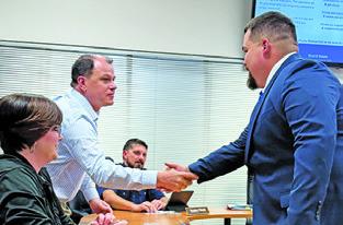 SNOOK SCHOOL BOARD member Adam Janac welcomes Matthew Kana to the Snook ISD family as its new athletic director and head football coach. Tribune photo by Denise Squier